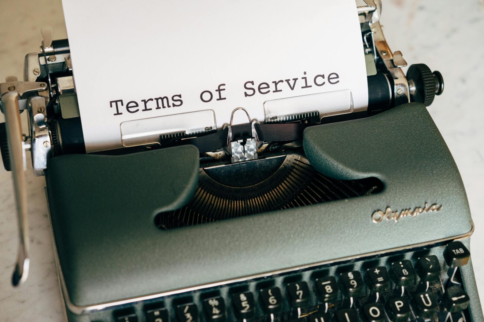 Close-up of a vintage typewriter printing 'Terms of Service' on paper, ideal for legal and business themes.